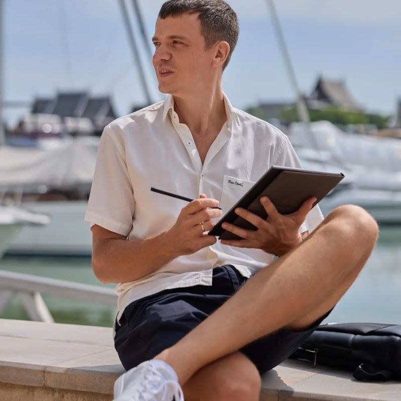 Kirill Patyrykin en chemise blanche, sur un port